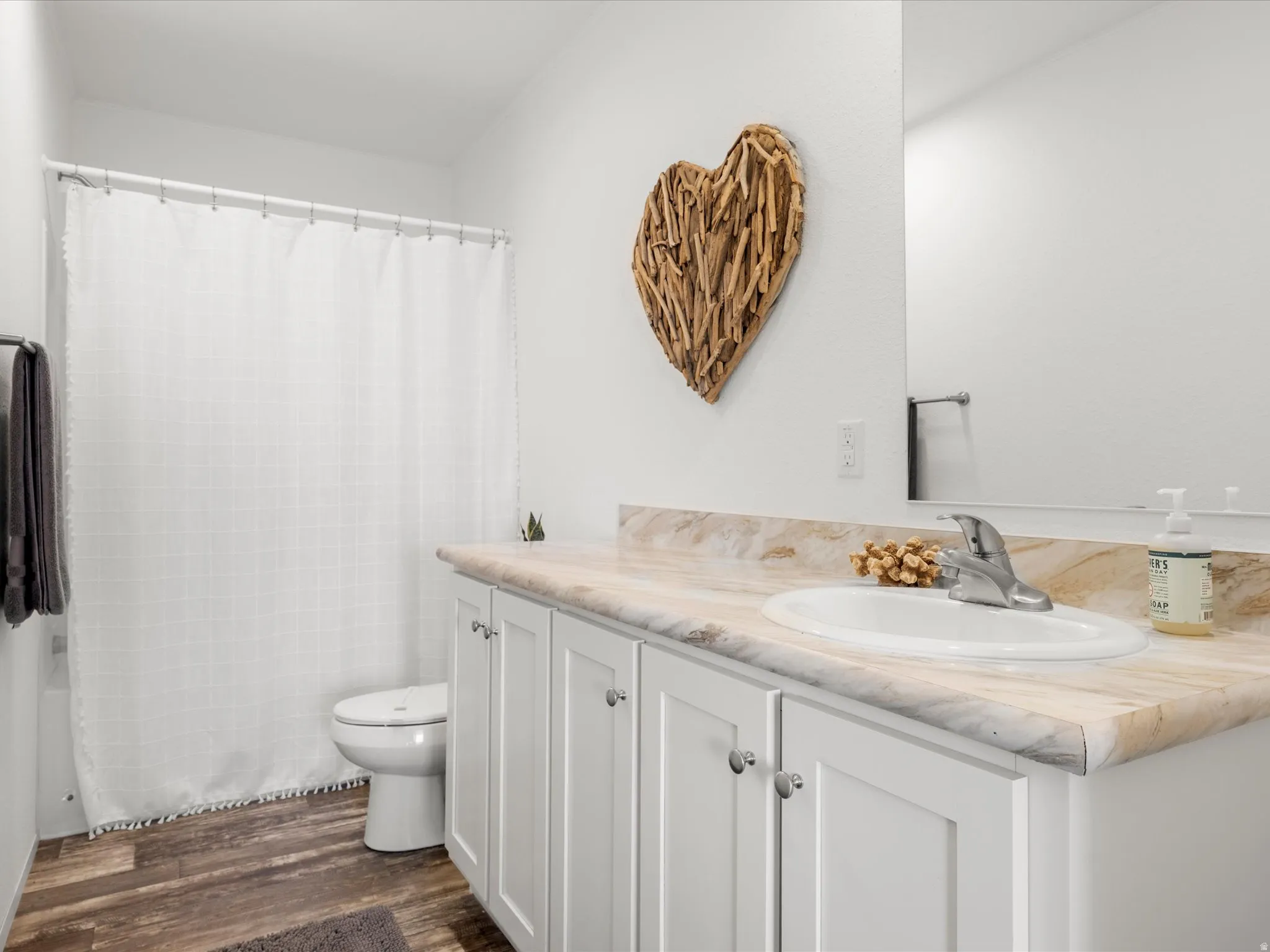 Vanity with white shaker-style cabinetry, undermount sink, and light-toned countertop