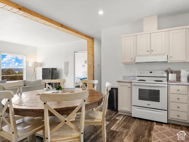 Kitchen featuring white cabinetry, white range, and stone-finish countertops