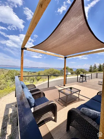 Expansive outdoor deck featuring a shade sail, wood pergola, and metal railing
