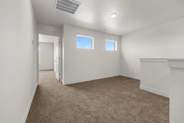 Recessed lighting, neutral paint, and carpet flooring