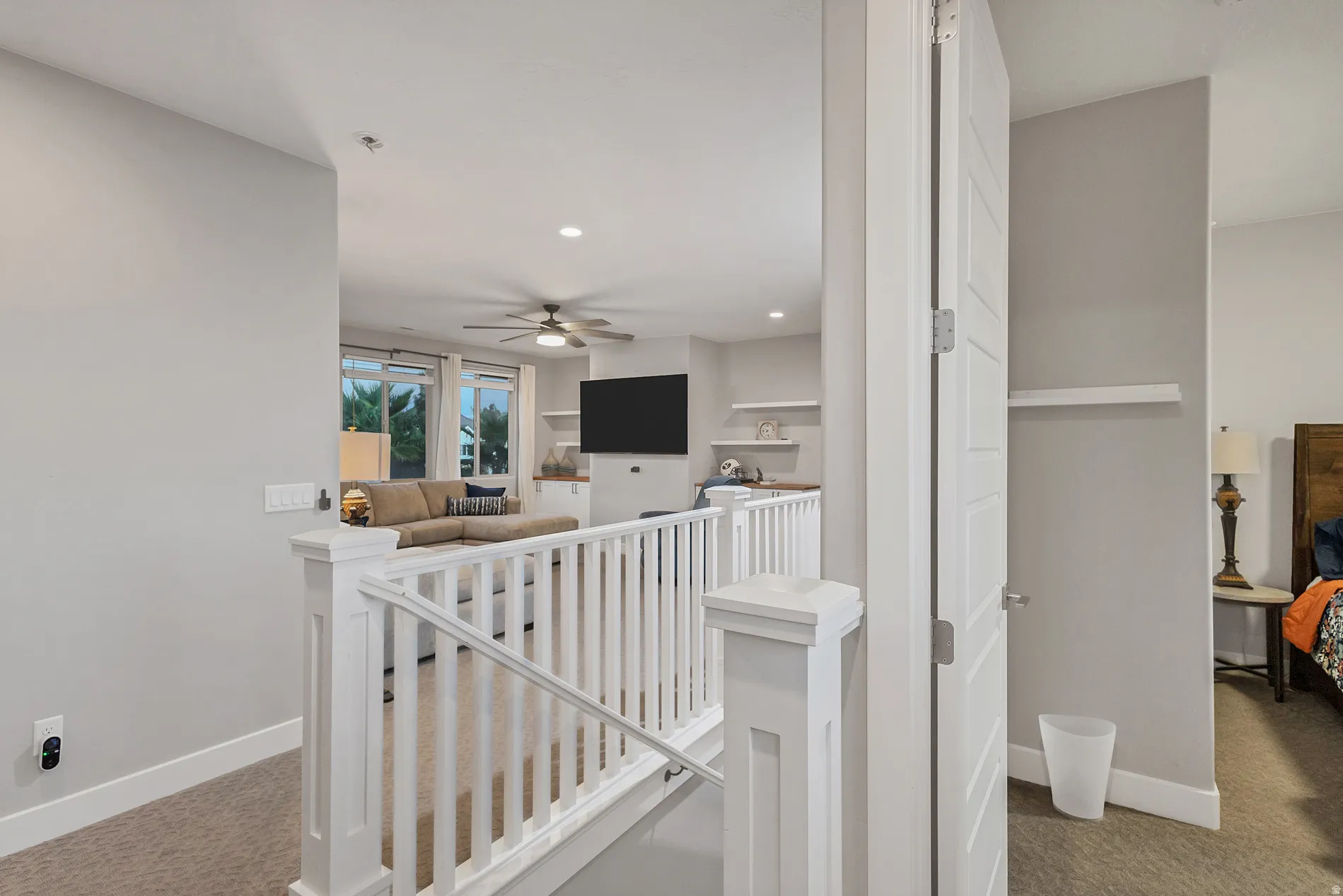 Carpeted upper level with white railing and trim