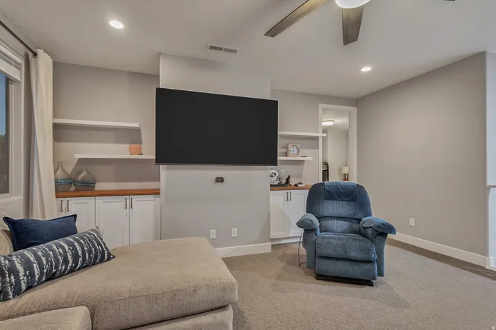 Built-in media center with shelving, recessed lighting, ceiling fan, and carpeted flooring