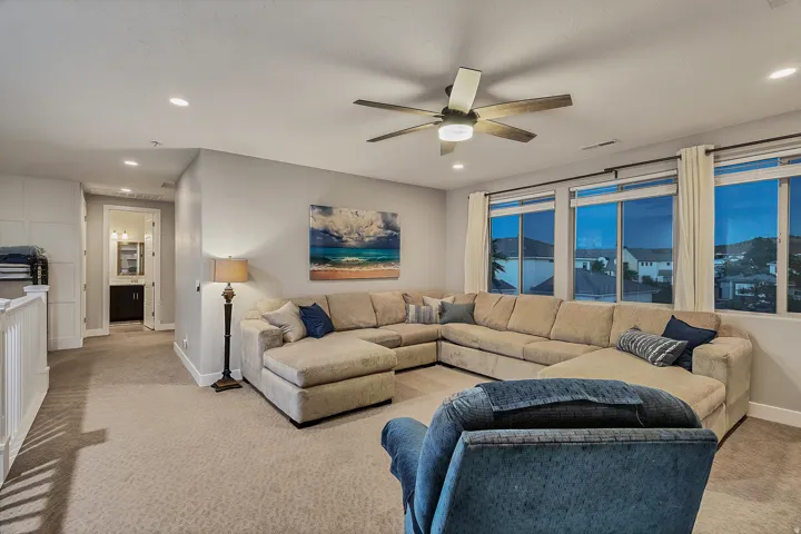 Recessed lighting, ceiling fan with light fixture, multiple large windows, wall-to-wall carpeting, and a built-in linen cabinet