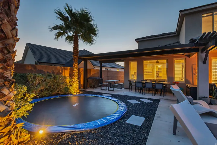 Expansive patio area featuring a pergola, concrete pavers, and a built-in outdoor dining space
