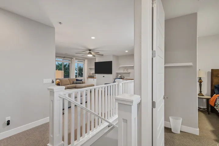 Carpeted upper level with white railing and trim