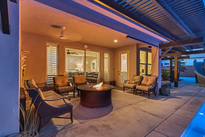 Covered patio with a built-in fire pit, exterior ceiling fan, and direct access to the interior