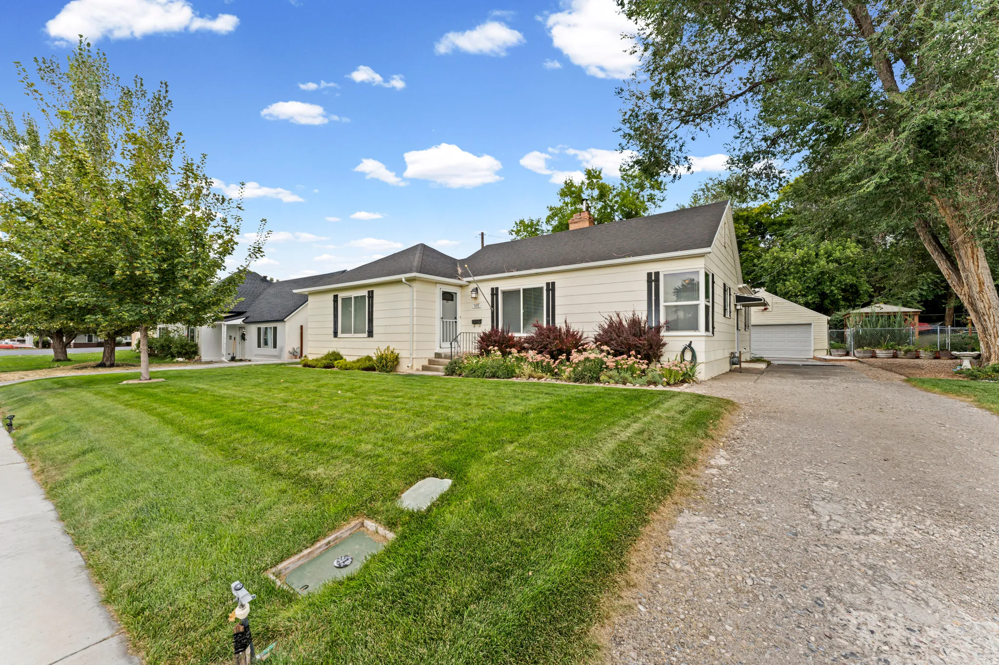 Single-story residence with a pitched roof, front landscaping, and a side-entry detached garage