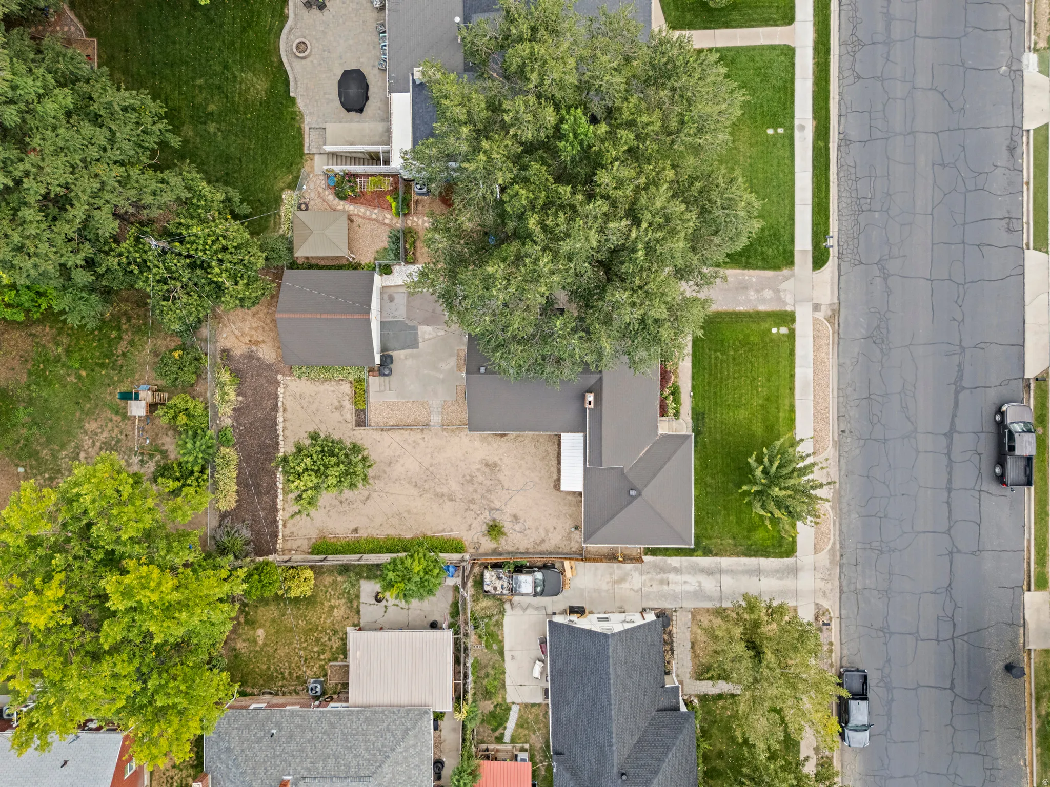 Expansive lot with mature trees, paved driveways, and established landscaping