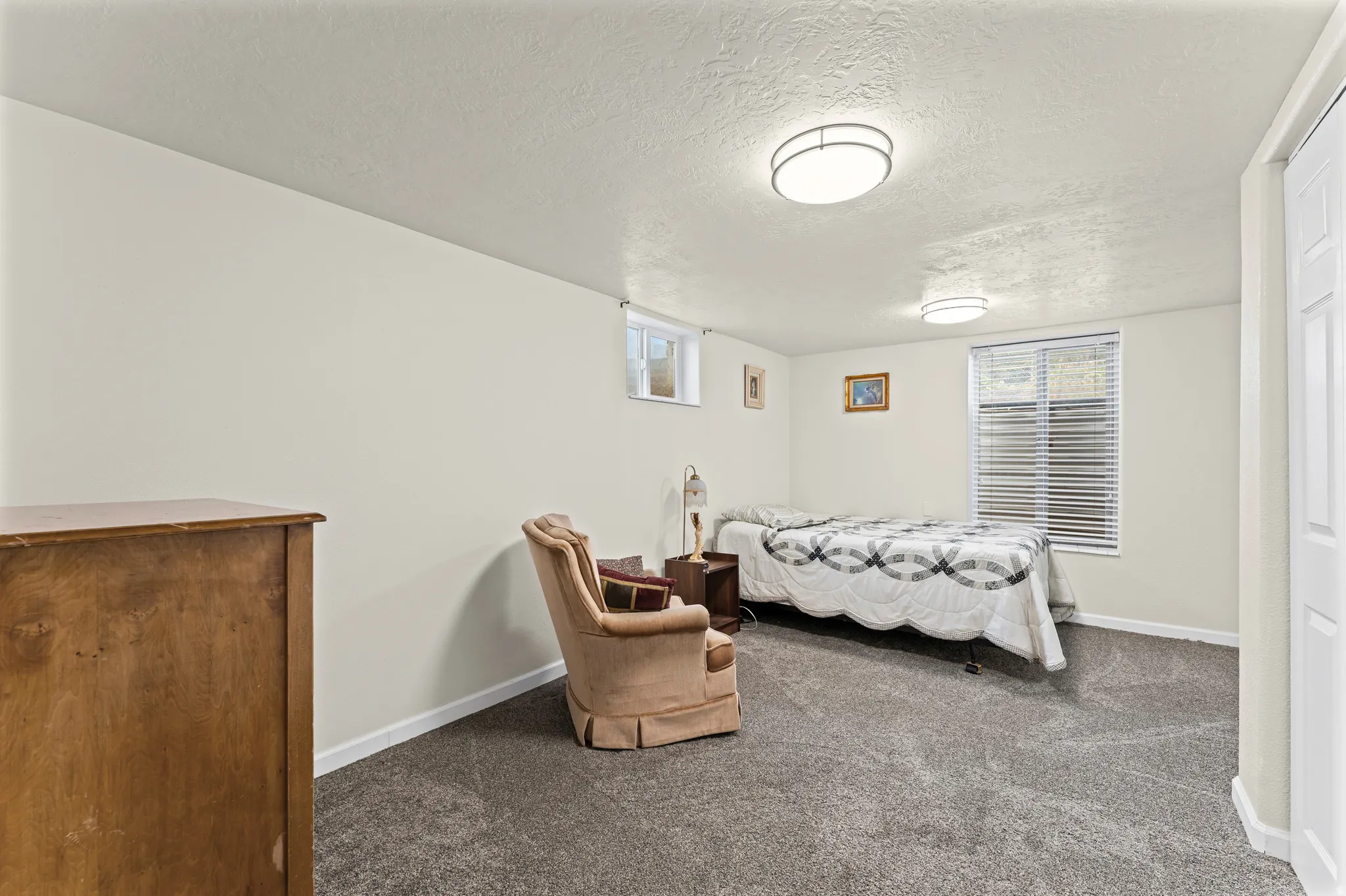 Recessed window with blinds, light-toned walls, gray carpeting, and flush-mount ceiling lights