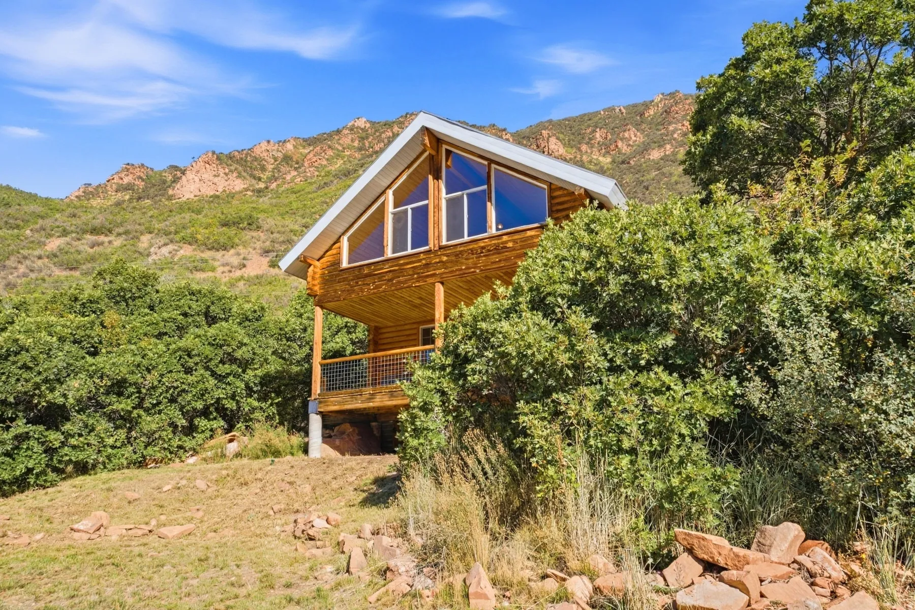 Log cabin exterior with an A-frame roof and prominent gable windows