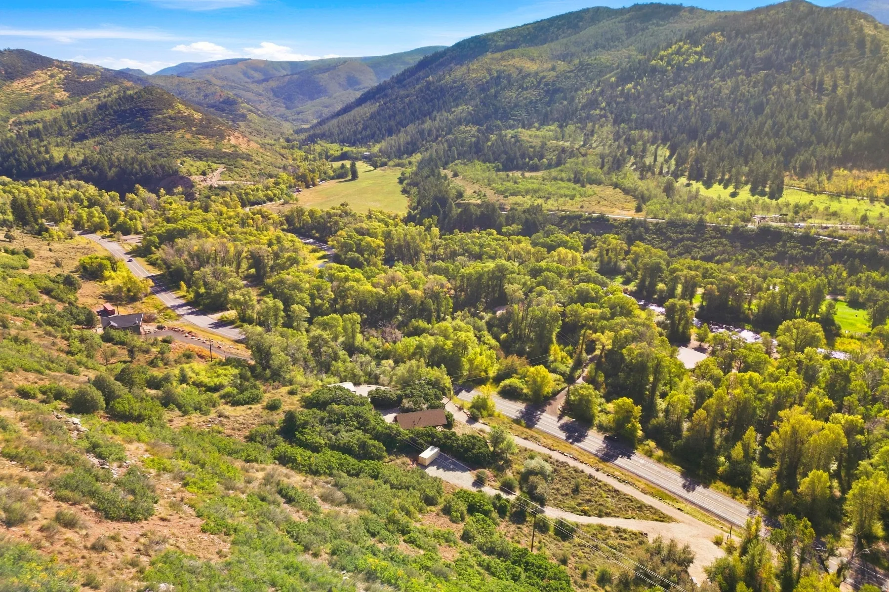 Mountainous terrain with lush green vegetation and a winding road