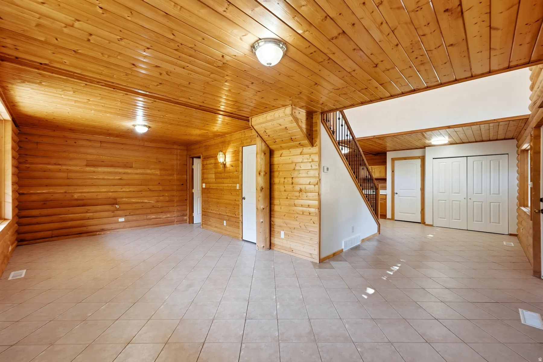 Pine wood paneling, tiled flooring, built-in staircase, and bi-fold closet doors