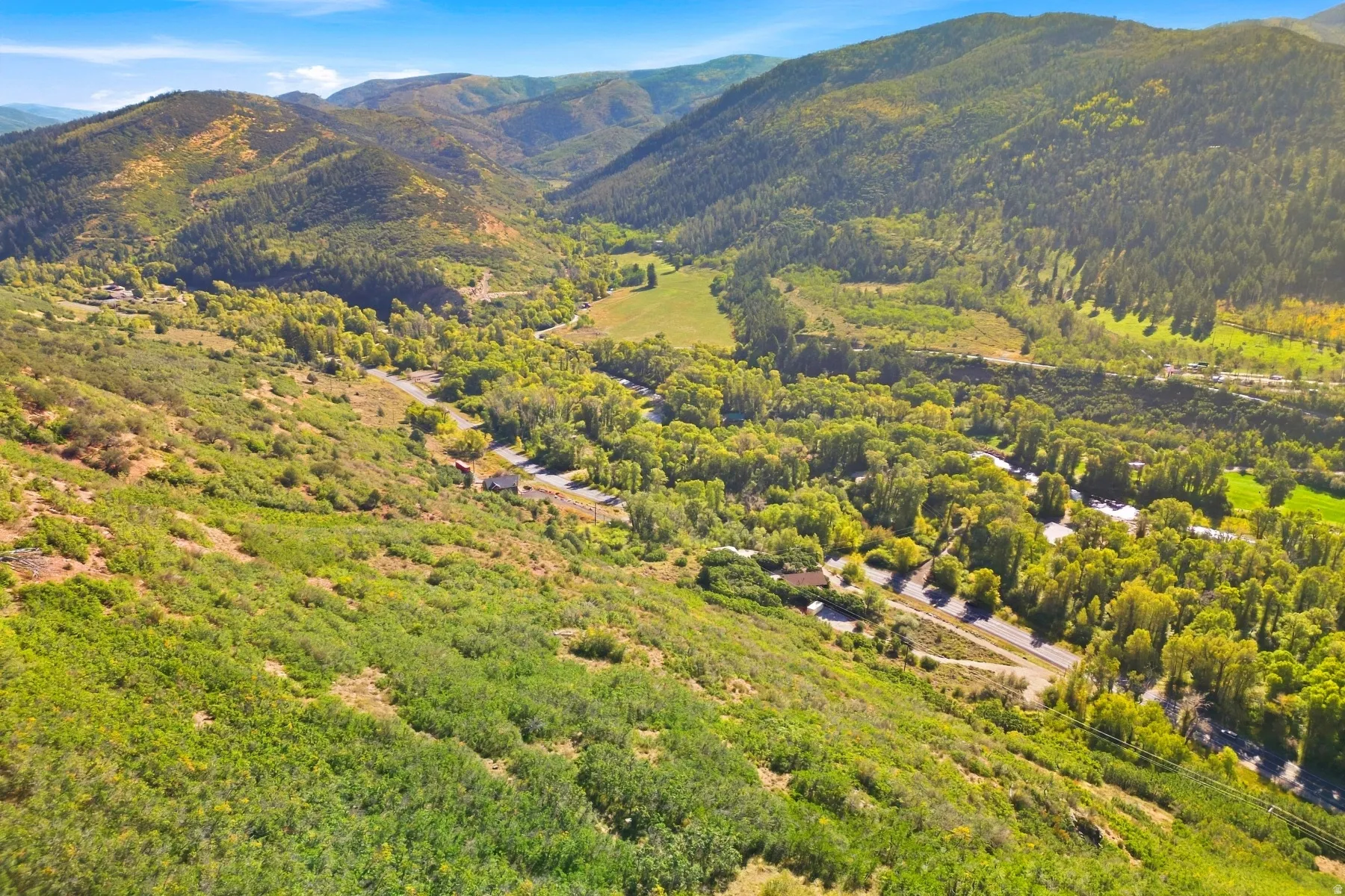 Expansive mountainous terrain with lush green foliage, showcasing natural topography