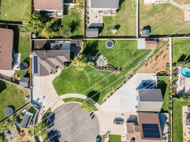 Expansive lot with a manicured lawn, dedicated patio space, and mature landscaping