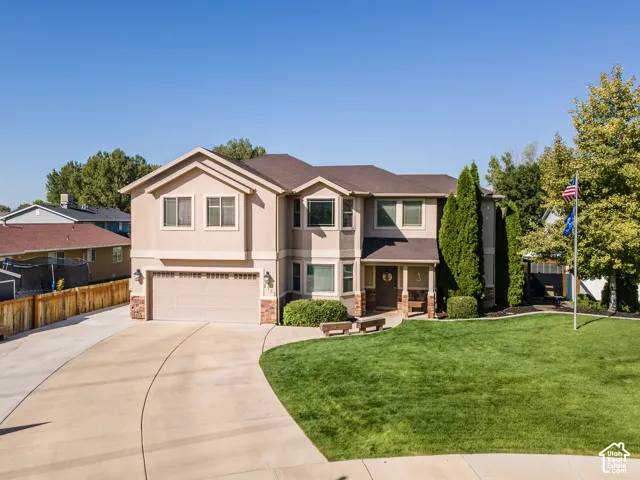 Two-story residence featuring stucco and stone veneer facade, an attached two-car garage, and a concrete driveway