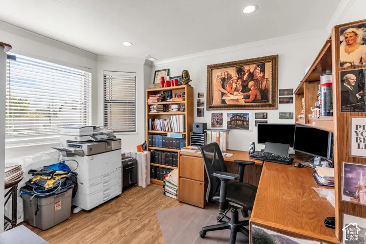 Spacious room featuring wood-finish flooring, multiple windows with blinds, and recessed lighting