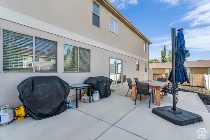 Expansive concrete patio with direct access via a sliding glass door, featuring a stucco exterior and multiple windows