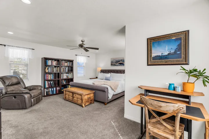 Carpeted room with recessed lighting, ceiling fan, and multiple windows with blinds