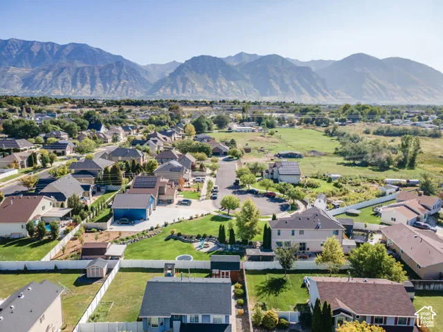 Residential neighborhood with mature trees, green spaces, and mountain backdrop