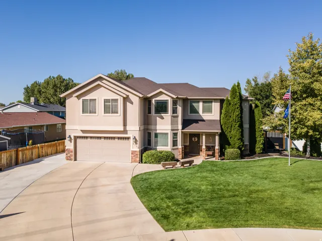 Two-story residence featuring stucco and stone veneer facade, an attached two-car garage, and a concrete driveway