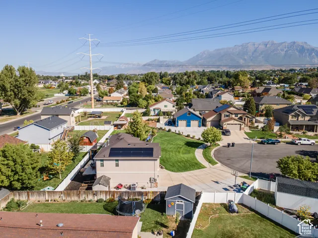 Residential neighborhood featuring varied architectural styles, mature trees, and mountain scenery