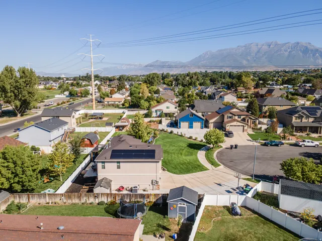 Residential neighborhood featuring varied architectural styles, mature trees, and mountain scenery