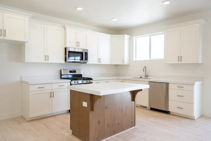 Terrific kitchen with 42" uppers, painted white wood cabinets, stained wood island, quartz slab countertops, gas range, microwave, dishwasher and disposal.