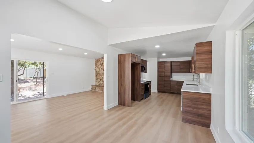 Updated kitchen with wood-finish cabinetry, white countertops, and stainless steel appliances
