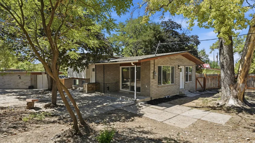 Brick exterior with multiple windows, covered patio, and a wood privacy fence