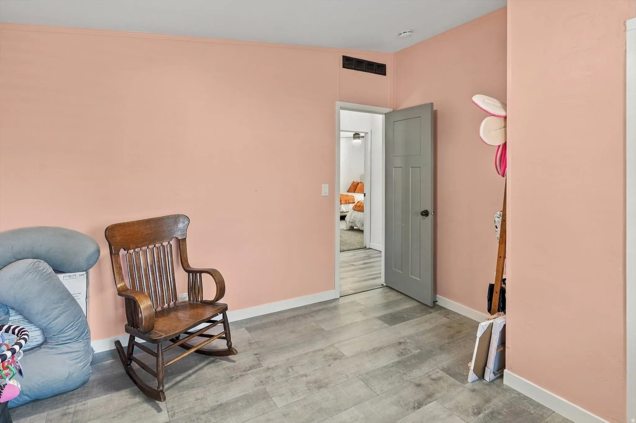 Wood-finish flooring with white trim and a paneled interior door