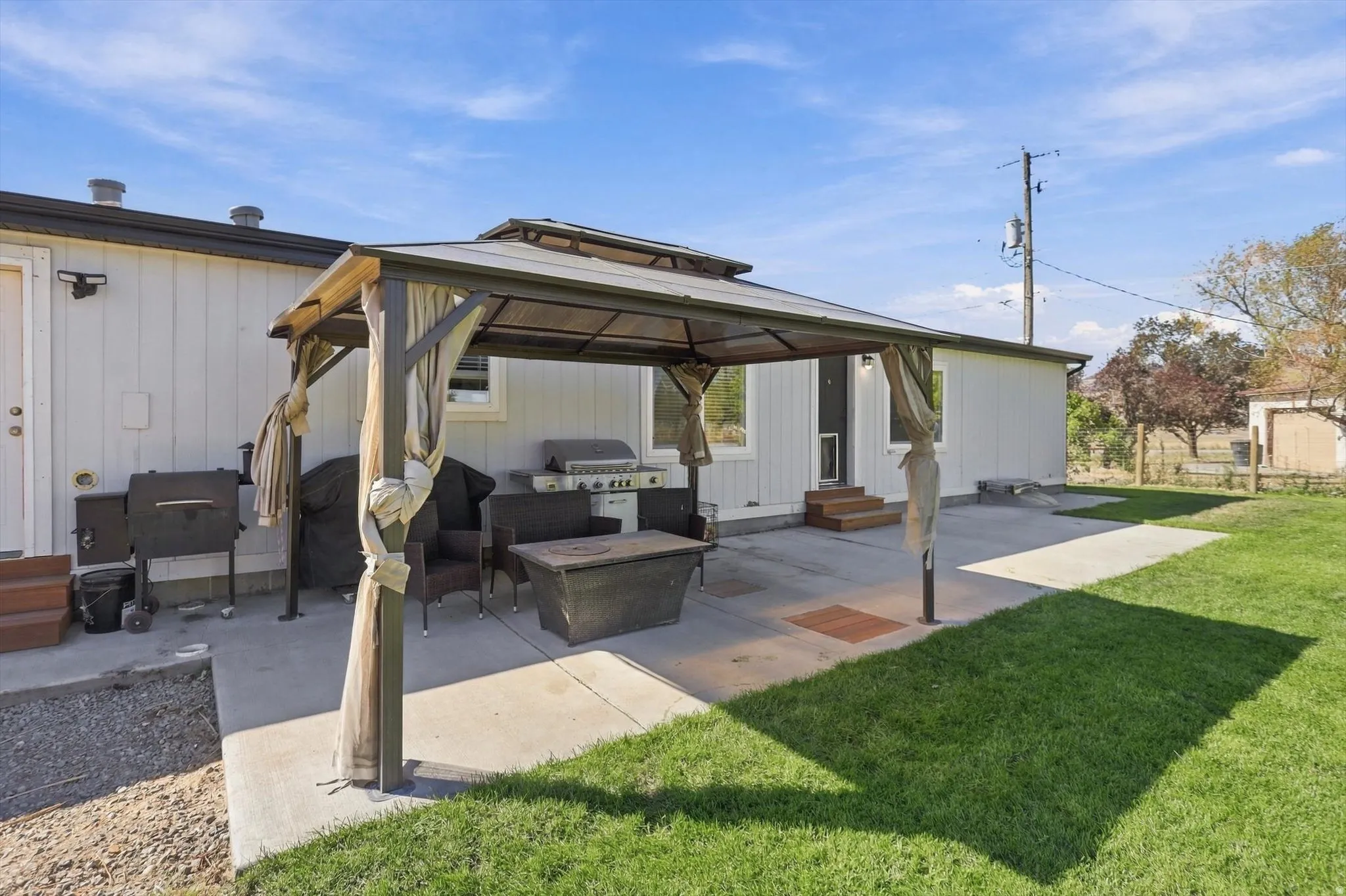Expansive concrete patio area with a permanent metal gazebo structure