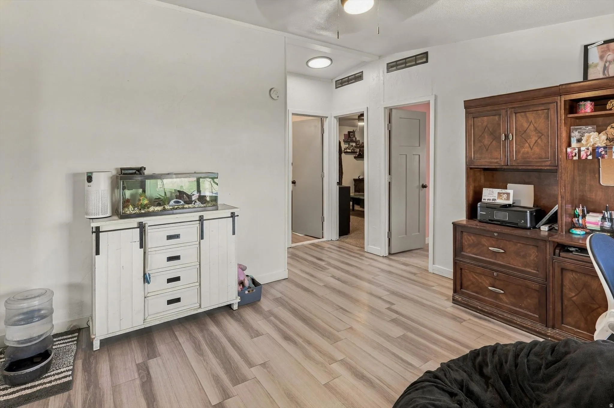 Wood-finish flooring throughout, white walls, recessed lighting, and a ceiling fan