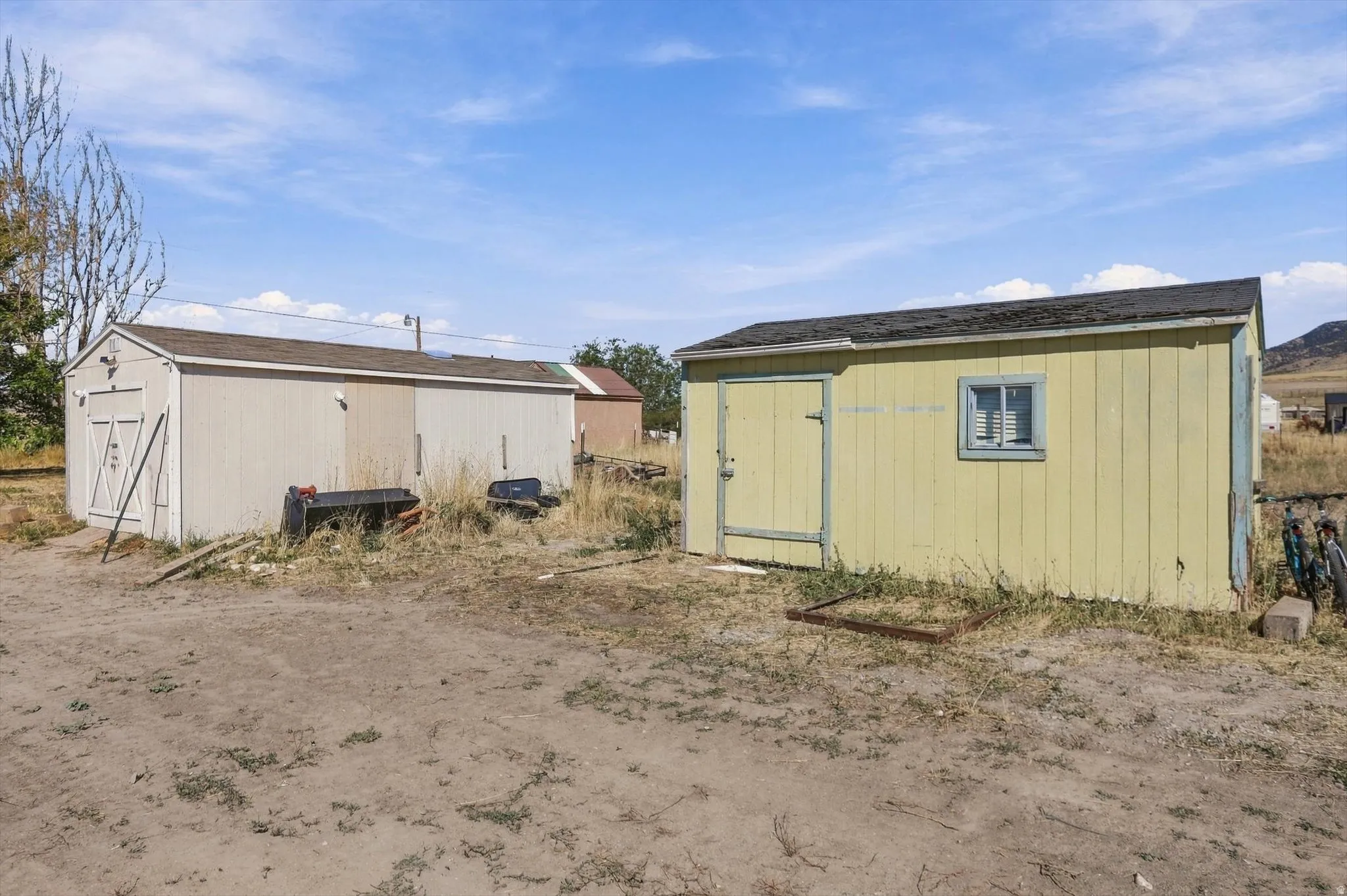 Two detached storage sheds with wood siding and composition shingle roofs