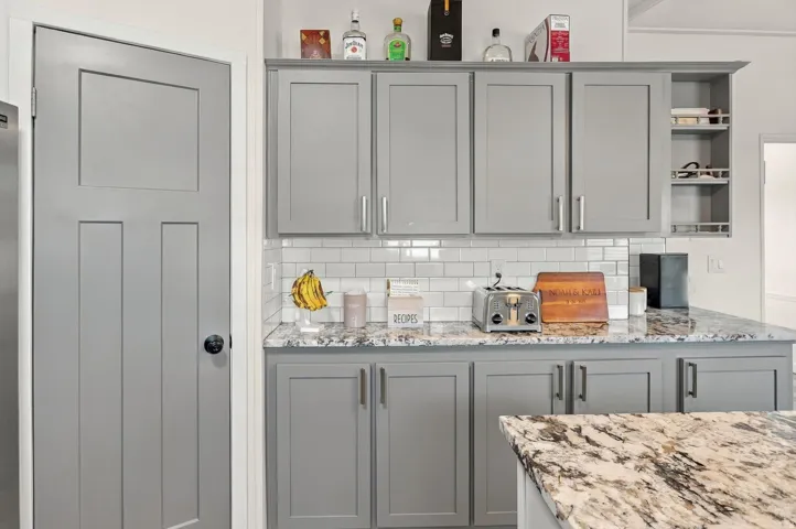 Gray cabinetry featuring brushed nickel hardware