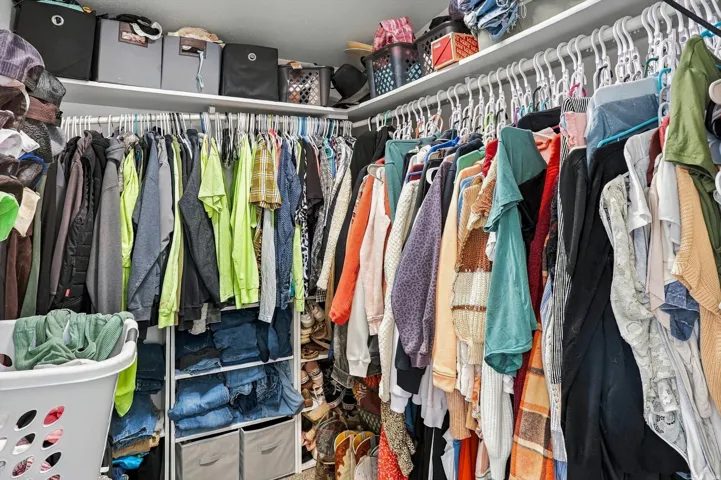 Custom closet organization system featuring multiple hanging rods, integrated shelving, and dedicated storage compartments