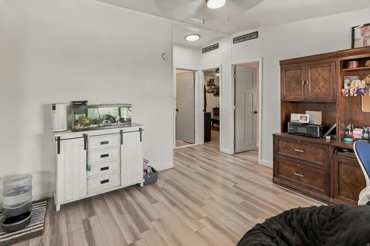 Wood-finish flooring throughout, white walls, recessed lighting, and a ceiling fan