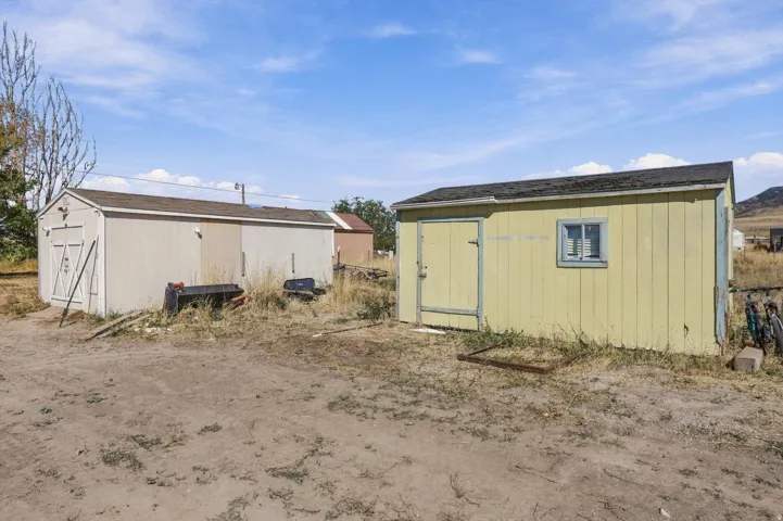 Two detached storage sheds with wood siding and composition shingle roofs