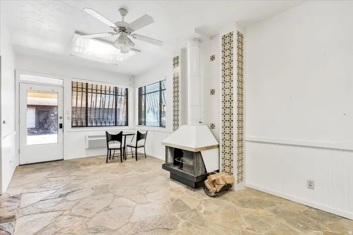 Flagstone flooring with a built-in fireplace featuring a tiled chimney