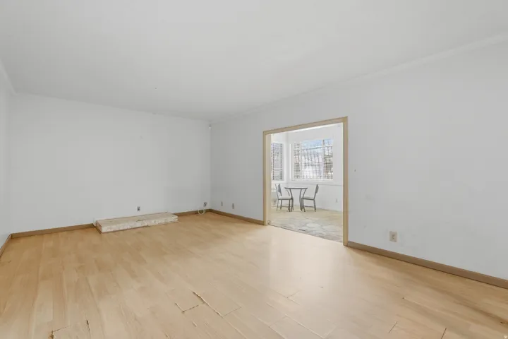 Wood-finish flooring throughout, white wall finishes, and crown molding