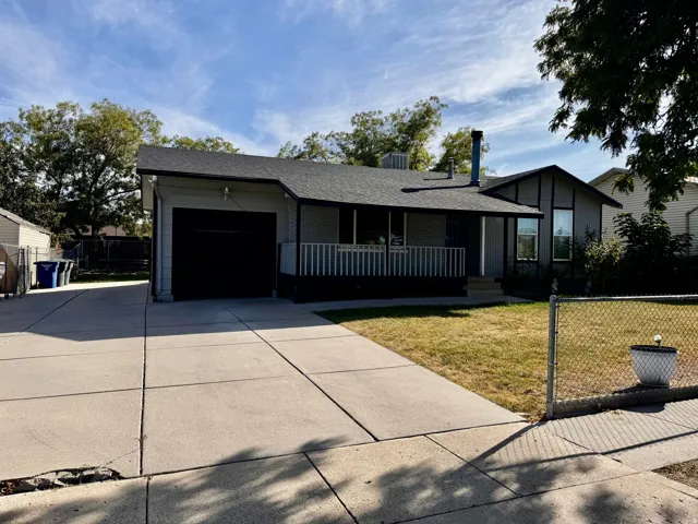 Single-story home with basement featuring a covered front porch, attached garage, and paved driveway