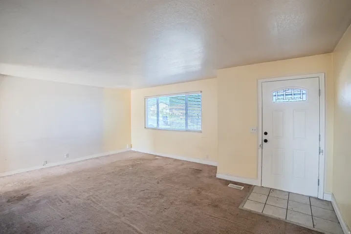 Entryway with tile flooring, a window with blinds, and light-colored walls