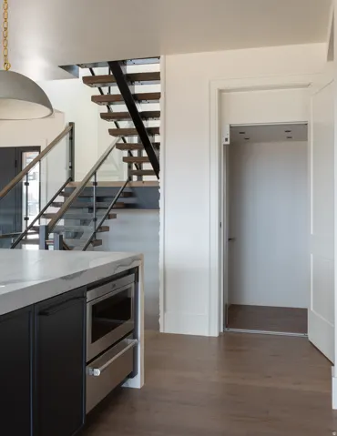 Floating staircase with glass panel railing and wood treads