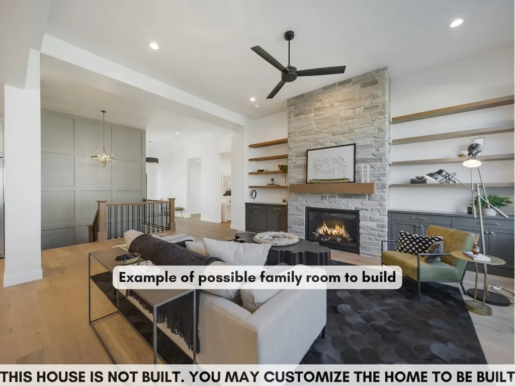Stone-clad fireplace with a wood mantle, built-in shelving, wood-finish flooring, and a contemporary ceiling fan
