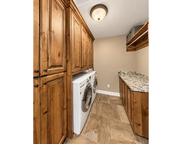 Extensive wood cabinetry, stone-finish flooring, built-in shelving, and a stone countertop