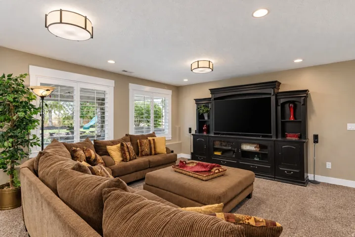 Built-in entertainment console, recessed lighting, and dual window openings with louvered shutters