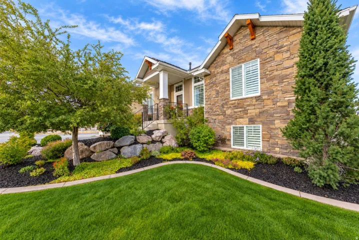 Stone veneer exterior with white window frames and plantation shutters