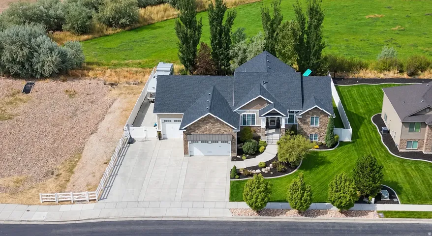Exterior featuring a stone and siding facade, multi-gabled roof, attached two-car garage, and an expansive concrete driveway