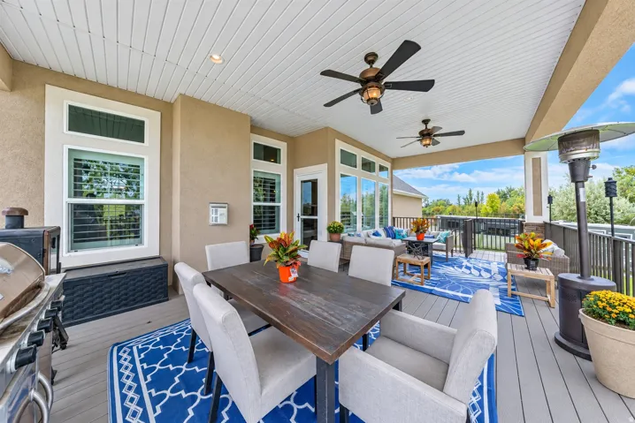 Covered outdoor living space with composite decking, recessed lighting, and dual ceiling fans