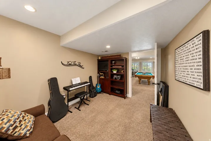 Carpeted room with recessed lighting and a built-in wood-finish shelving unit
