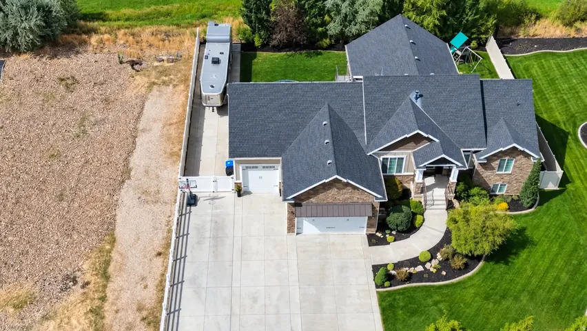 Expansive property featuring a multi-gabled roofline, a concrete driveway, a two-car garage, and a lush green lawn